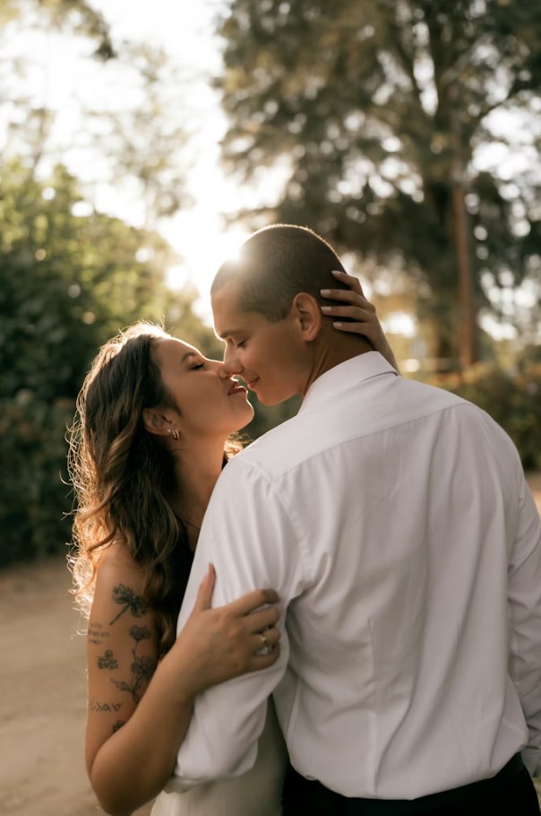 Pareja en jardín con velo fluyendo, boda al aire libre